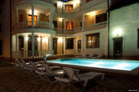 снимок бассейна и фасада гостиницы ночью